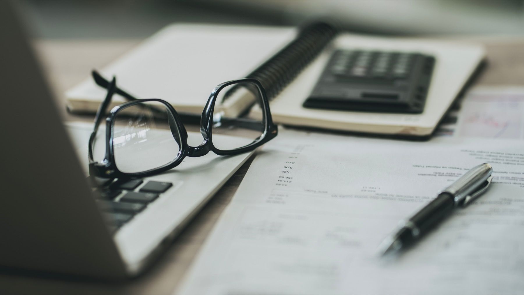 Glasses, pen, and documents prepared for house-style review.