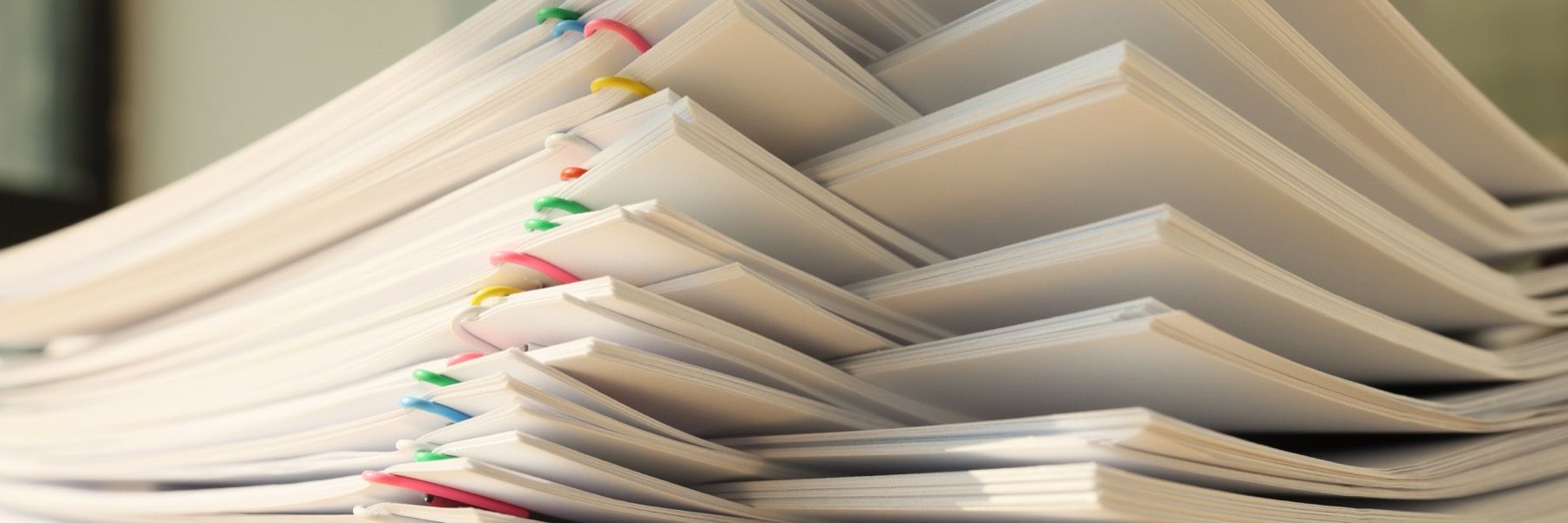 Stacked documents with tabs ready for board pack review.