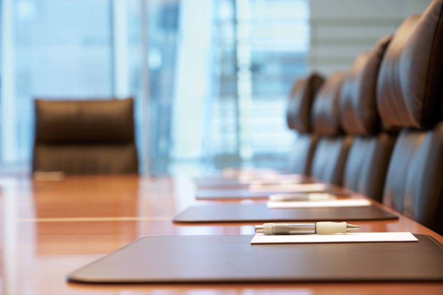 Formal boardroom table prepared with papers for public terms.