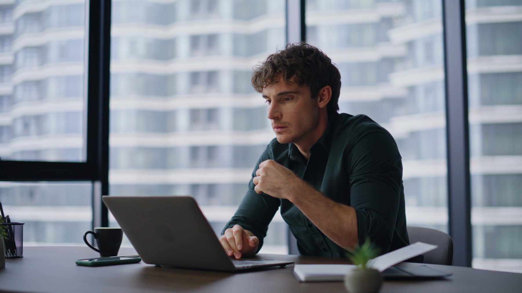 Professional working at a laptop in a quiet office.