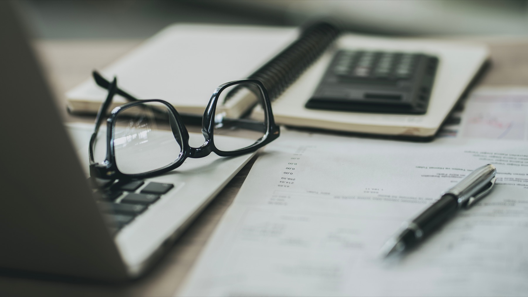 Glasses, pen, and documents prepared for house-style review.