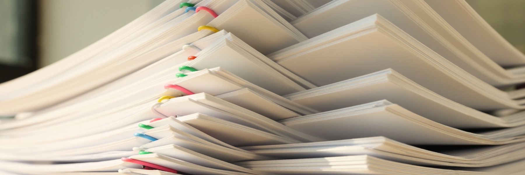 Stacked documents with tabs ready for board pack review.