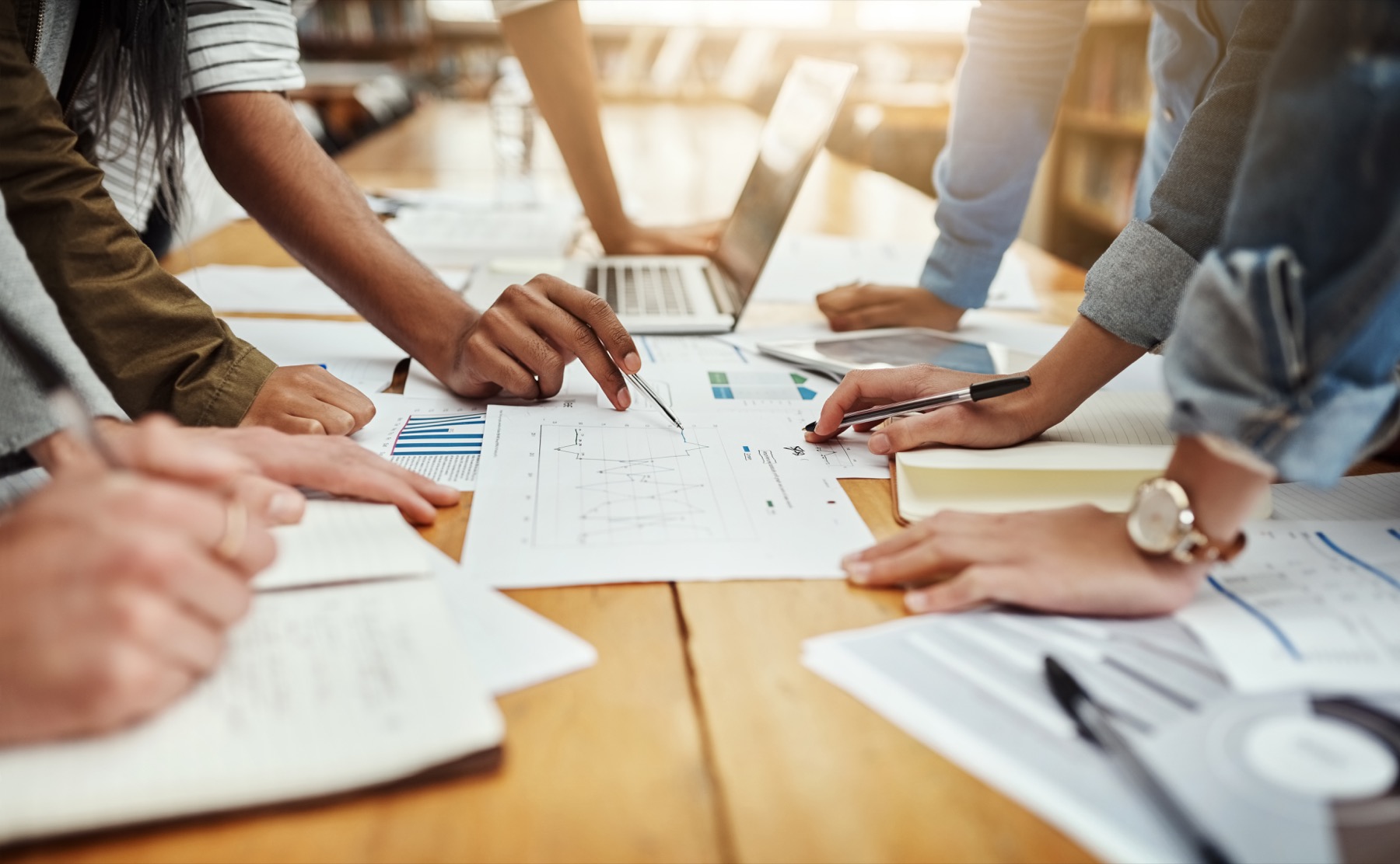 Hands around board papers for a representative evaluation review.